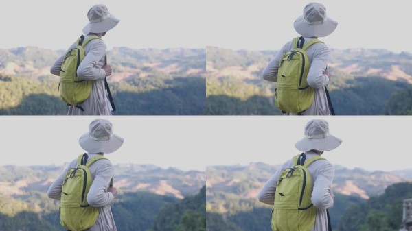 背着相机背包的男性旅行者，户外旅行生活方式与冒险概念。戴着帽子的背包客与游客一起参加绿色山脉之旅，欣