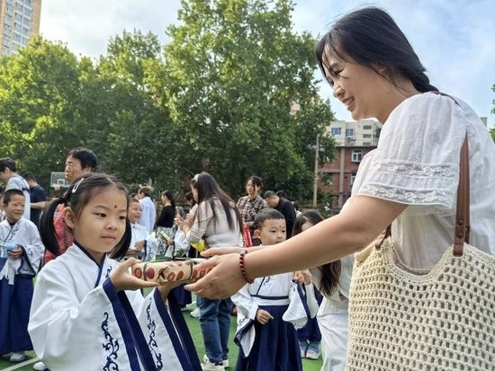 在西电实验小学，一年级新生家长为孩子送上入学礼物。记者 王燕摄