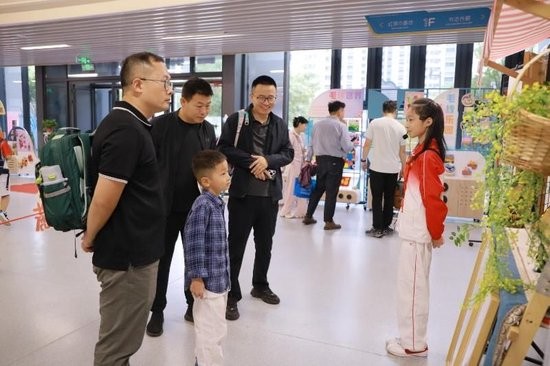 高新十五小新生和家长游园探校，高年级学生为学弟学妹们介绍校园（记者 程静摄）