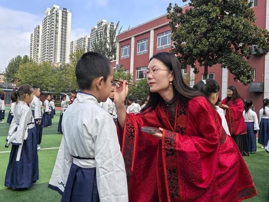 在西电实验小学，老师们为一年级新生点朱砂，以传统启蒙教育形式祝福孩子们眼明心亮、智慧启航。记者 王燕摄