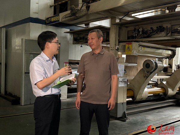 银行工作人员走访启越纸品。人民网记者 杜燕飞摄