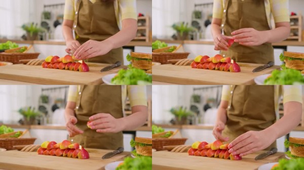特写镜头：早晨在家中，女性在厨房烹饪健康食品。迷人的家庭主妇感到快乐和放松，享受准备食材并制作水果沙
