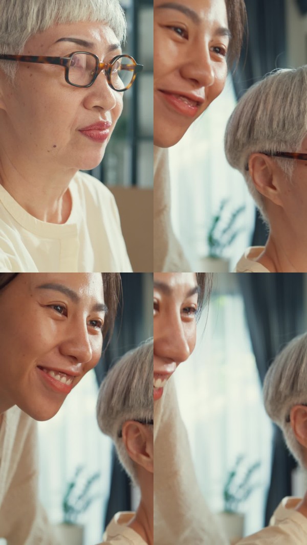 特写镜头:快乐的亚洲家庭,女儿在客厅里享受看着年长的母亲在画布上绘制色彩斑斓的艺术作品,周末一起度过