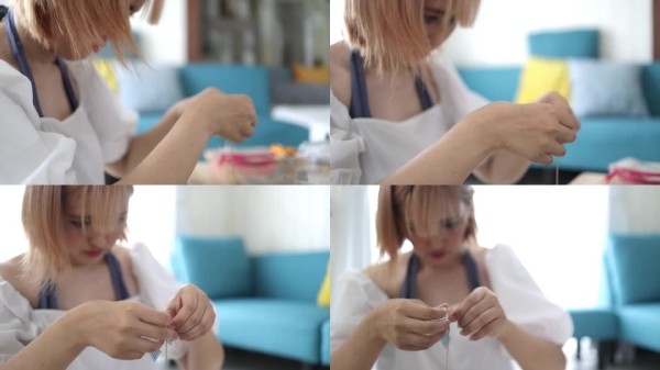 年轻的女艺术家在家里制作个人饰品
