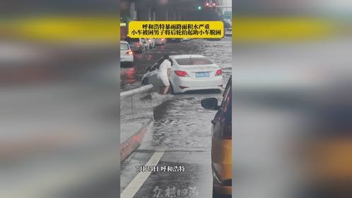 路面积水小车被困，男子将车后轮抬起帮助车辆脱困！