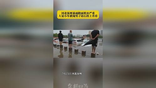 河北涿州暴雨路面积水严重，小车被淹男子站石柱上查看