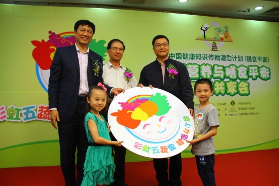 向小朋友代表赠送“彩虹五蔬果，健康从小做”徽章