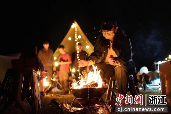 游客点燃篝火体验露营。 王凯 摄