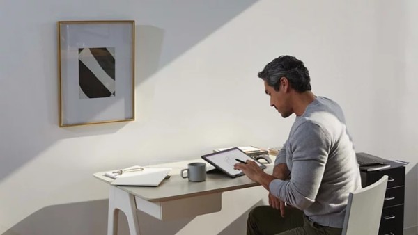 一名男子在其家庭办公室使用 Surface Pro 和 Surface 触控笔工作