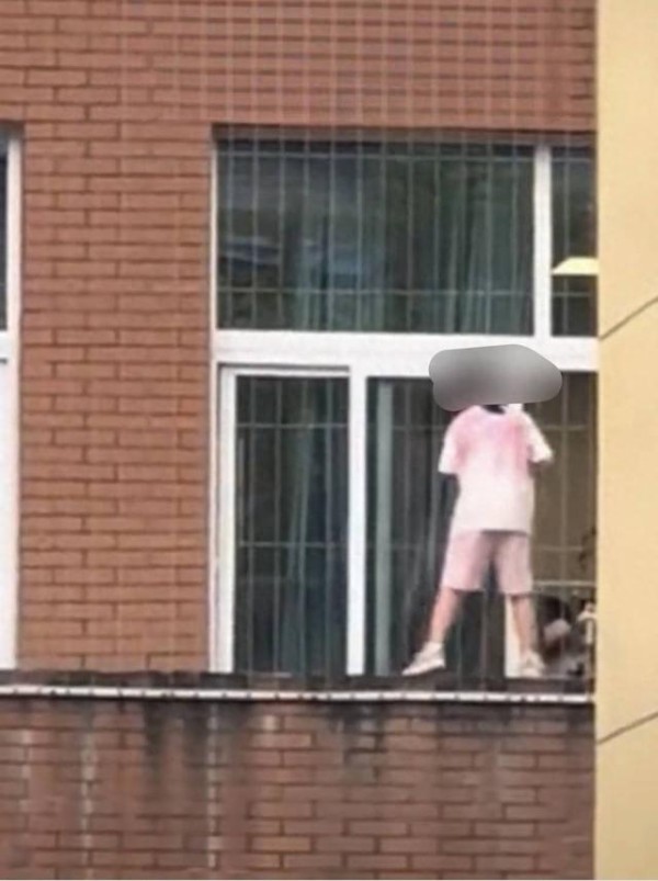 网友发布的视频截图显示:一小学生在窗台上打扫。图据网友视频