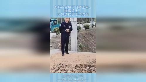 大妈在空屋门口晒玉米，被撒泥土，大妈边捡泥土边流泪