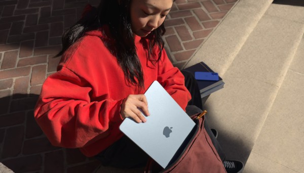 一位学生将 MacBook Air 放入背包中
