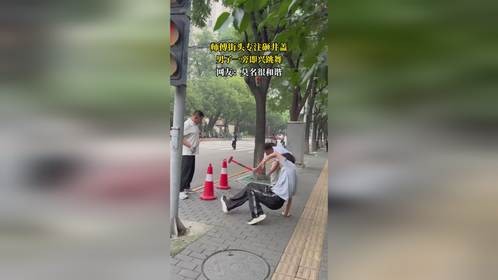 师傅街头专注砸井盖，男子一旁即兴跳舞，网友：莫名很和谐