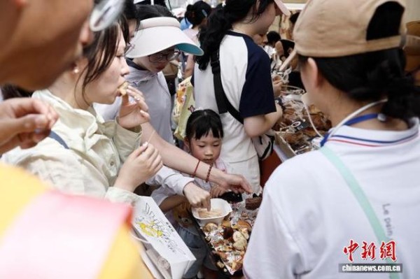 10月2日,市民带着孩子品尝面包。中新社记者 殷立勤 摄