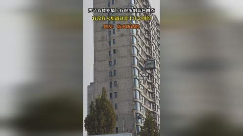 男子看楼外墙上有很多的蓝色圆点，有没有人知道这是干什么用的