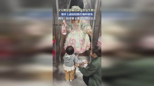 宝宝被穿洛丽塔裙子的女生吸引，缓步上前轻轻抓住她的裙角。