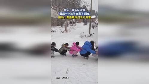 雪天一家人玩滑雪，最后一个孩子充当了 刹车