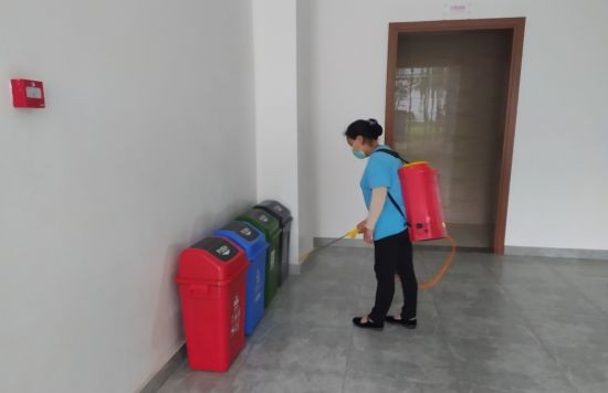 图为工作人员对垃圾桶进行消毒。明孝贤 摄