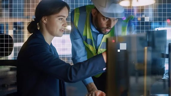 兩位同事一坐一站,檢視並排桌上型電腦顯示器所顯示的一組影像與編輯工具。背景顯示白色網格圖案,表示正在使用 AI