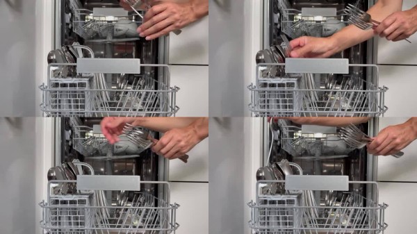 女性的手从洗碗机篮子里取出清洗干净的餐具。家务。