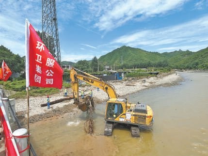 环卫工人在牤牛河清理倒伏树木。 钟静摄