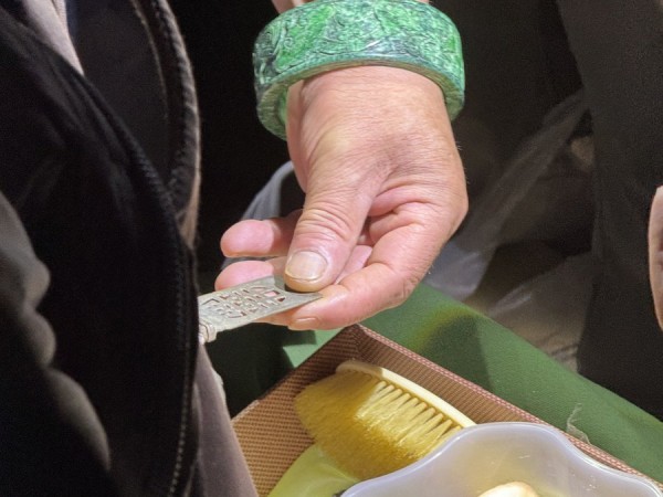 围观者正在观察古玩商品。