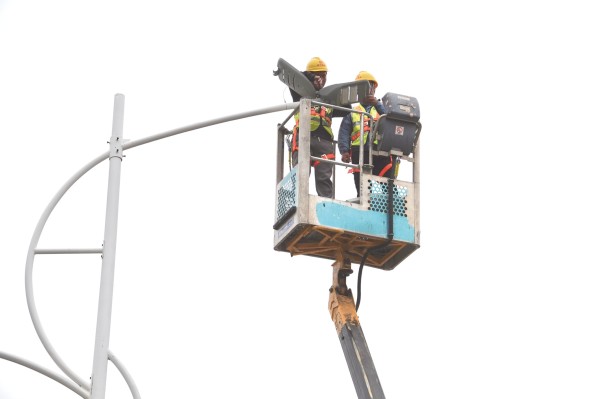 ▲南宁城市运营集团工作人员对良庆区龙堤路沿线路灯进行改造。