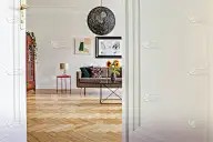 客厅内台灯下沙发旁的桌子上放着向日葵，还有海报。真实的照片