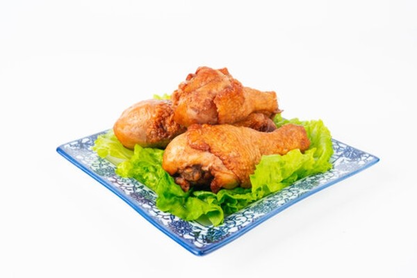 正在组装汉堡的过程特写,手拿着鸡腿准备放入面包中