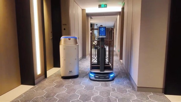 图为配送机器人和行李机器人，劳动报记者颜筱依摄