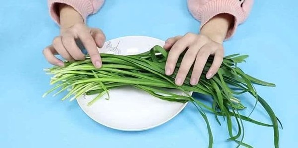 家庭厨房中准备韭菜红糖料理的画面