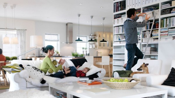 一家人和宠物狗共同在宽敞明亮的开放式家庭娱乐室中活动。屋内家具或采用轻质木材，或为白色。