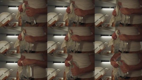 男人用柔软的白色抹布擦干干净的玻璃盘子，在整洁的家庭厨房完成洗碗过程，特写。日常生活中卫生和条理的概