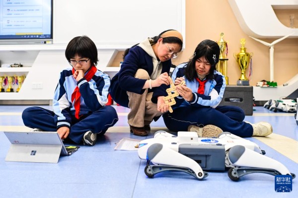   12月2日，杭州市保俶塔实验学校的学生们在人工智能通识课上学习如何给机器狗编程。新华社记者 江汉 摄