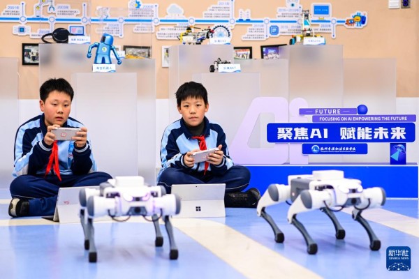  12月2日，杭州市保俶塔实验学校的学生们在人工智能通识课上学习如何给机器狗编程。新华社记者 江汉 摄