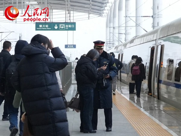 1月4日，银川火车站工作人员正在帮助旅客核对乘车信息。人民网记者 梁宏鑫摄