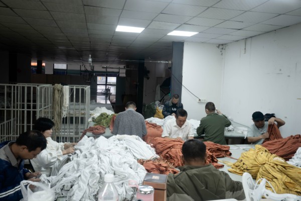 ▲尾部车间里，尿毒症工人在剪线头。新京报记者 吴瑜 摄