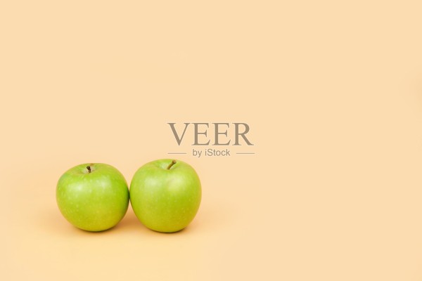 浅色背景上放着两个绿苹果,留有干净的复制空间,代表着健康饮食、营养选择、极简生活方式和新鲜有机食品的概念。照片摄影图片