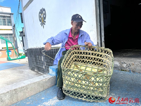 【2】杨有松正在编制竹篾桌。人民网-尹馨摄