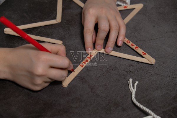 用冰淇淋棍制作的圣诞星星。环保装饰的DIY创意礼物。零浪费手工制作的节日礼物,适合儿童DIY项目,共度亲子时光。照片摄影图片