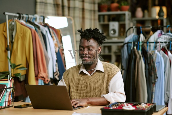 年轻的黑人男性在店内在线销售二手服装照片摄影图片