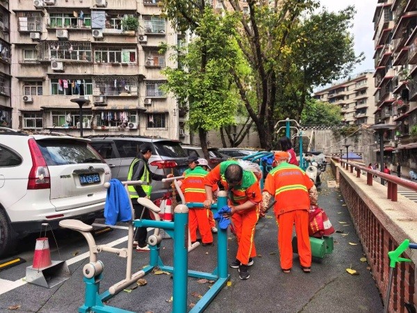 志愿者们正在擦拭健身器材和清扫落叶。刘莎莎摄