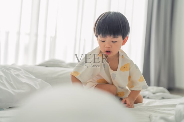 令人愉悦的亚洲幼儿,两到三岁,睡醒后穿着睡衣,充满童真、纯粹的兴奋和活泼的童年能量,在温暖放松的家庭氛围中,快乐地玩耍、好奇地探索、开心地笑着、跳跃着、跑来跑去。照片摄影图片